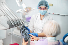 Woman Medic Presenting Dental Radiograph To Retiree