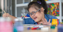 Excited Girl With Down Syndrome Smiling And Painting