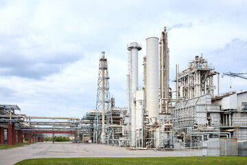 Large-capacity ammonia production workshop. Exterior of modern petrochemical plant with reactors and converters under heavy sky with copyspace.