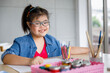 © Bangkok Click Studio - Young Asian down syndrome little girl sitting at desk with colors prepare for painting. She widely smiles with bright eyes and happiness and looking to camera. Concept for education for disabled kid.