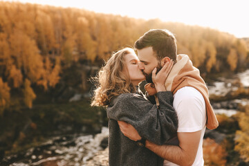 Happy in love romantic young cheerful couple man and woman married travel hiking walk together among the autumn forest and mountains looking for adventure enjoy the local nature, selective focus