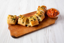 Homemade Chicken Parmesan-Stuffed Garlic Bread On A Rustic Wooden Board On A White Wooden Background, Side View.