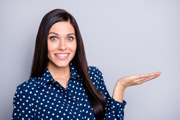 Sticker - Photo of optimistic nice brunette girl hold empty space wear blue blouse isolated on grey color background