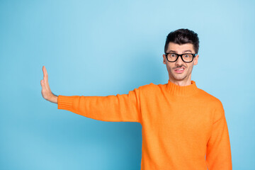 Poster - Photo of negative young guy grin teeth show arm palm rejection empty space isolated on blue color background