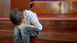 © WilliamBank - Young Christian Asian Boy Sitting on Steps Praying to God at Church with Hope and Faith