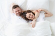 © megaflopp - Smiling happy man and woman lie on large white bed