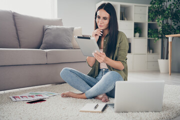 Poster - Full size photo of attractive positive lady sit on floor barefoot hand on chin look minded tablet working home indoors