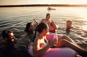 Wall Mural - Friends enjoying a summer day swimming at the lake.