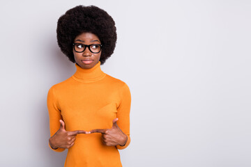 Wall Mural - Photo portrait of shy afro american girl touching pointing fingers together looking at blank space isolated on clear grey colored background