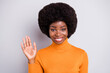 © deagreez - Portrait of charming curly hairstyle dark skin lady arm wave you toothy smile isolated on grey color background