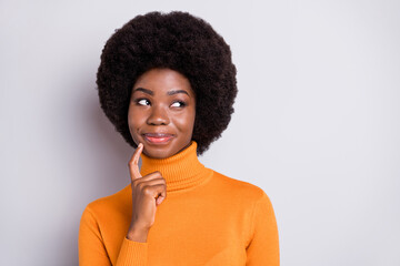 Sticker - Portrait of charming curly hairstyle dark skin lady finger on chin look empty space isolated on grey color background