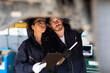 © NVB Stocker - Hispanic Female trainee Mechanics Working Underneath Car Together Car maintenance and auto service garage. Car maintenance and auto service garage concept.