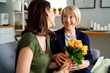 © gpointstudio - Surprised mother gets a bouquet of flowers from adult daughter