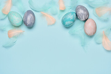 Happy easter minimal background. Easter eggs and feathers on blue pastel background. Flat lay, copy space