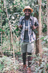 Wall Mural - Happiness African man traveler with backpack walking  in the forest