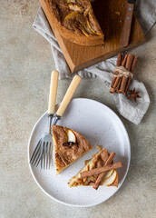 Wall Mural - Two pieces of apple pie with cinnamon on a plate, light concrete background. Semolina cake with apple and spices. Homemade mannik.