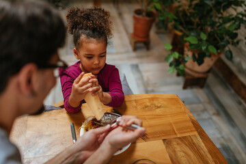 Little girl helping his father int he kitchen