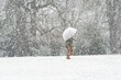 During a snowstrom, a man walking with umbrella in Bushes Pasture Park,Salem,Oregon