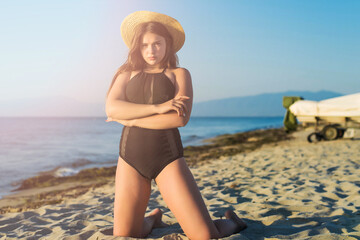 Wall Mural - Cheerful plus size teenage girl wearing hat enjoying the beach. smiling, happy, positive emotion, summer style.