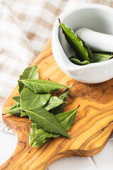 Sticker - Fresh green bay leaves in white mortar.