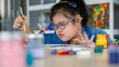 © Bangkok Click Studio - Excited girl with Down syndrome smiling and painting