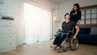 An asian man in a wheelchair in the home after a car accident and his wife to give encouragement. The concept of Mutual care and new technology has made people with disabilities Equality in society.