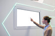 © zyabich - White screen, mock up, future, copyspace, template, technology concept. Woman touching blank digital interactive white display wall at exhibition or museum with futuristic scifi interior