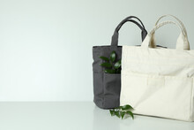 Stylish Eco Bags And Twigs On White Background