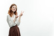 © SHOTPRIME STUDIO - pretty red-haired woman in formal suit holds hands in front of her emotions fun light background