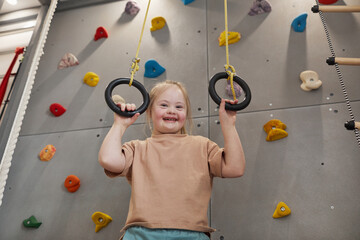 waist up portrait of cute girl with down syndrome enjoying exercise at home or at sports center and 