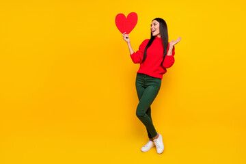 Sticker - Full size photo of young beautiful charming smiling excited girl hold big red paper heart isolated on yellow color background