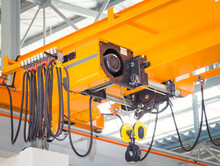 Overhead Crane Inside Factory Or Warehouse. That Industrial Machinery Or Lifting Equipment Consist Of Hoist, Hook And Wire Rope Traveling On Beam Girder Structure. For Manufacturing Production Plant.