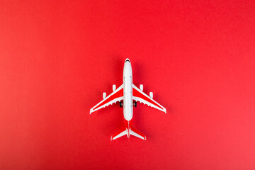 Wall Mural - toy model of a modern airplane. tourism and travel concept. red background