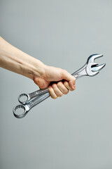 two wrench composition in male hands isolated on gray