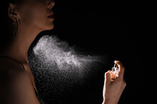 Woman Spraying Luxury Perfume On Black Background, Closeup
