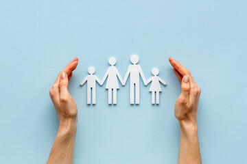 Wall Mural - Hands holding family figure top view. Insurance concept