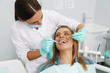 © Drobot Dean - Woman sitting in medical chair while dentist fixing her teeth