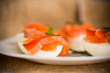 Wall Mural - halves of boiled eggs with pieces of salted salmon