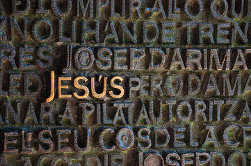 Word Jesus on bronze Gospel door of Passion facade of Sagrada Familia basilica. Barcelona, Spain. Black white historic photo.