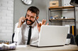 © JustLife - Young businessman talking to the phone. Businessman in office using the phone.