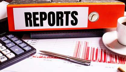 Fototapete - The red document folder says REPORTS next to the coffee, calculator and pen.