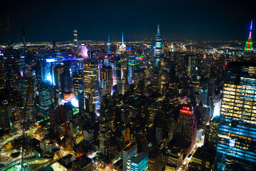 Fototapete - Night scene across the city of Manhattan, New York City with many illuminated buildings on a dark night