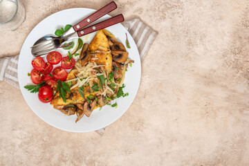 Wall Mural - Omelet with mushrooms top view. Tasty breakfast or lunch. Omelet with champignons, cheese, and tomatoes in a white plate on the table. Free space for text