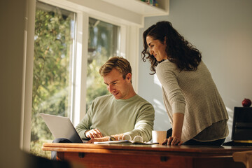 Couple at home working on a laptop together