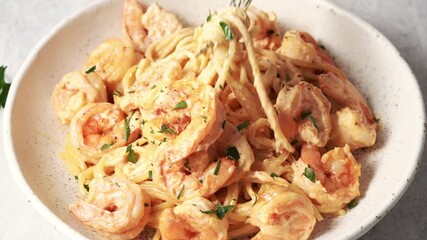 Wall Mural - Person stirs plate with fork, pokes shrimp paste and lifts it up. Mixing dish in bowl, eating meal. Pasta bavette with fried shrimps, bechamel cream sauce on plate, close up italian cuisine.