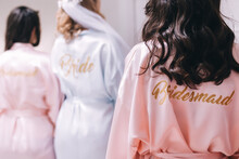 Back View Of A Group Of Bridesmaids With The Bride-to-be In Beautiful Silk Robes With Different Names On The Back.