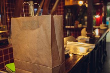 dessert paper bag waiting for customer on counter in modern cafe coffee shop, food delivery, cafe restaurant, takeaway food.