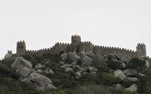 The Castle Of The Moors Located On A Hilltop Above The Town Of Sintra, Portugal On A Cloudy Day