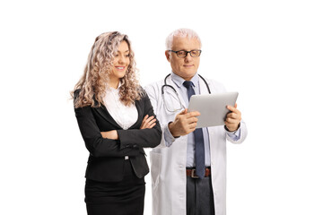 Wall Mural - Mature doctor and a businesswoman looking at a tablet