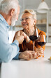 © Goran - Loving senior couple communicating while drinking wine at home